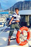 Boy teen sailor mooring boat rope in harbor