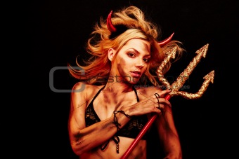 Beautiful devil with trident and Halloween accessories on black