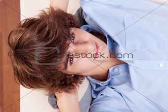 young man, lying on the couch. Studio shot.