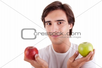 Portrait of a young man with two apples in their hands: green and red. Concept of choice
