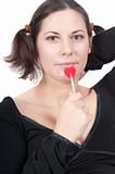 Portrait of pretty woman in black eating candy