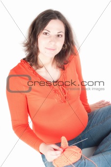 Portrait of pretty pregnant woman knitting