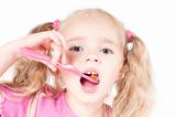 Little cute girl in studio brushing teeth