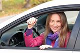 The happy woman showing the key of her new car 