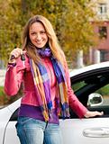 The happy woman showing the key of her new car