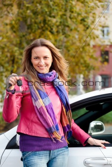 The happy woman showing the key of her new car 