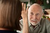 Senior couple at home focusing on angry man