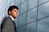Young businessman looking to good future on modern building background
