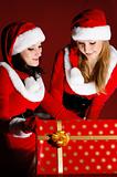 two woman in Santa costume opening christmas gift