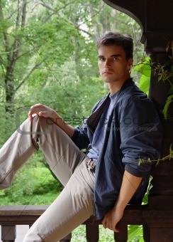 Relaxed young man sitting at wood
