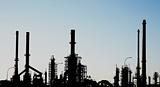 Silhouette of an oil refinery with chimneys