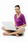 woman sitting on the floor with laptop on white background studio