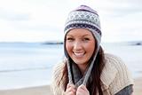 Joyful woman wearing hat and scarf on the beach