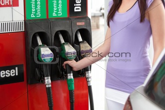 Pretty caucasian woman refueling her car