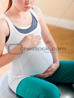 Close-up of a pregnant woman exercising on a ball