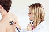 attractive female doctor using stethoscope on her patient's back