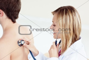 attractive female doctor using stethoscope on her patient's back