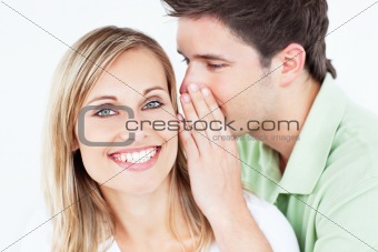 handsome man whispering something to his girlfriend against a wh