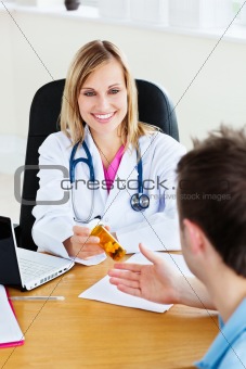 Smiling doctor givng pills to her patient 