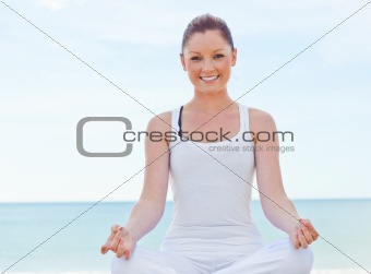 Youg caucasian girl doing yoga overr sea background 
