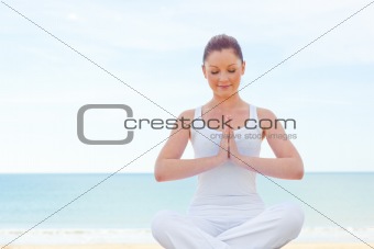 Concentrated woman practicing yoga on the beach 