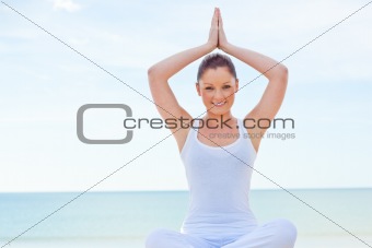 Portrait of young woman doing yoga exercise on the beach 