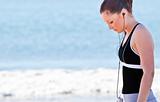 Athletic woman listening music on the beach 