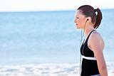 Young woman listening music on the beach 