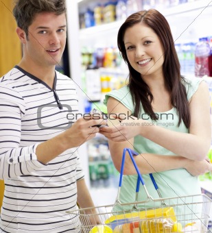 Young caucasian couple buying shampoo standing in a department o