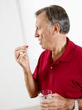 senior man eating pills