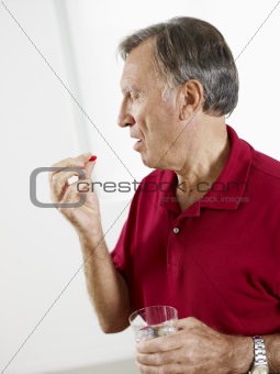 senior man eating pills