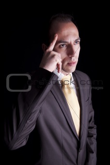 Portrait of a young business man thinking, isolated on black background. Studio shot.