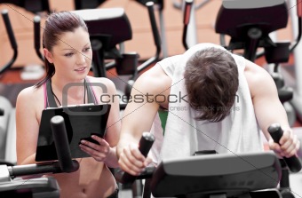 Exhausted man doing exercises while his coach is looking at his 