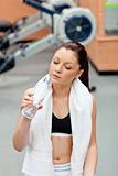 cute athletic woman drinking water after exercises in a fitness 