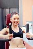 beautiful athletic woman using a bench press smiling at the came