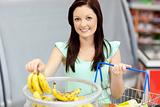 healthy woman with shopping-basket buying bananas in a grocery s