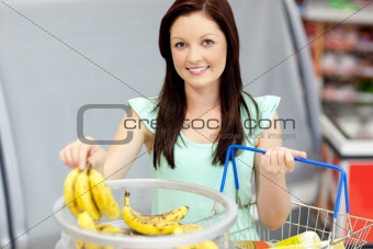 healthy woman with shopping-basket buying bananas in a grocery s