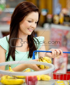portrait of an attractive woman buying bananas and apples