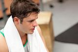 Exhausted male athlete with a towel after working out