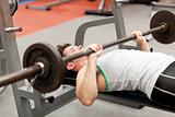 muscular young man using weightlifting lying in a fitness centre