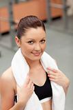 attractive athletic woman with towel around the neck smiling at 