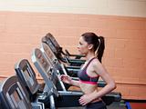 Serious female athlete doing exercises on a treadmill in a fitne