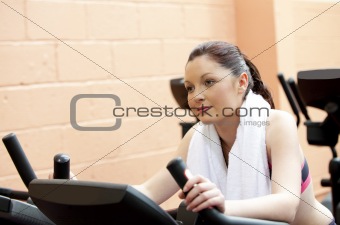 Beautiful woman training on a bicycle in a fitness center 