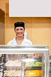 Portrait of a cute baker smiling at a customer in a  cafeteria