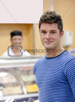 Portrait of a cheerful man choosing his lunch in the cafeteria