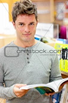 Serious young man reading a book