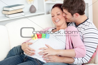 Portrait of a happy pregnant woman with baby cubes on her belly 