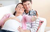 Close-up of a cheerful pregnant woman and her husband taking pic