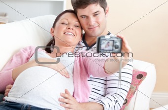 Close-up of a cheerful pregnant woman and her husband taking pic