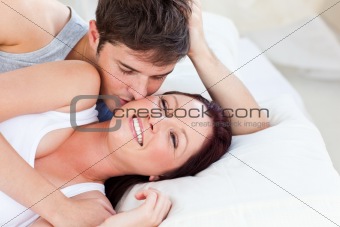 Caring caucasian couple lying on bed in the bedroom